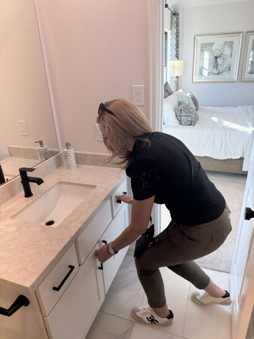 Person opens bathroom cabinet door