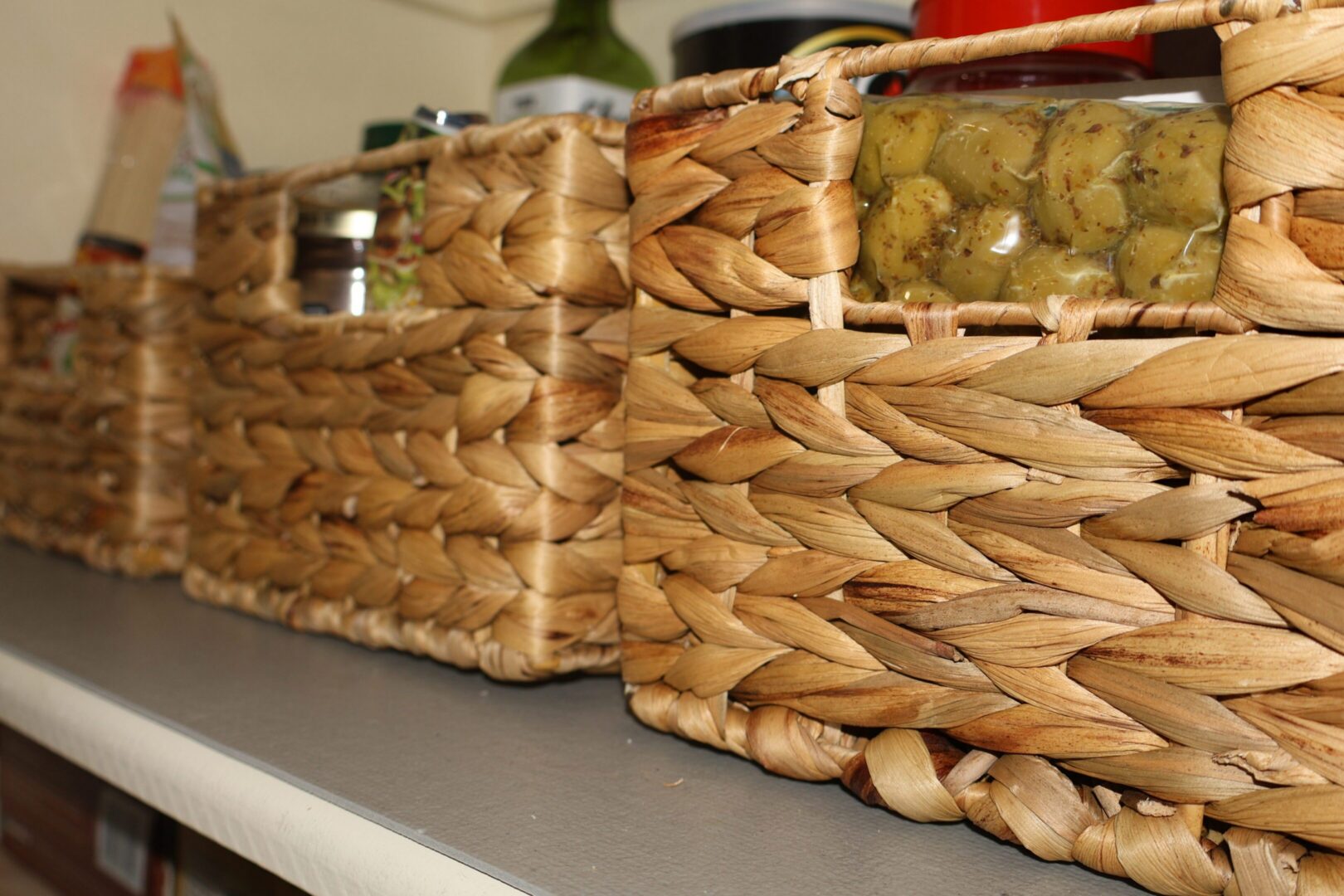 Woven wicker baskets with jars on countertop